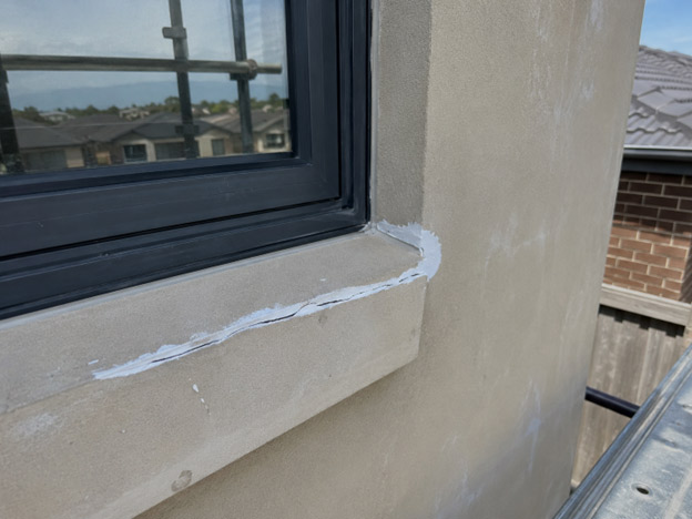 "Hairline crack repair at window sill on brick veneer home in Grand Lakes Lara — flexible filler applied before exterior repaint"